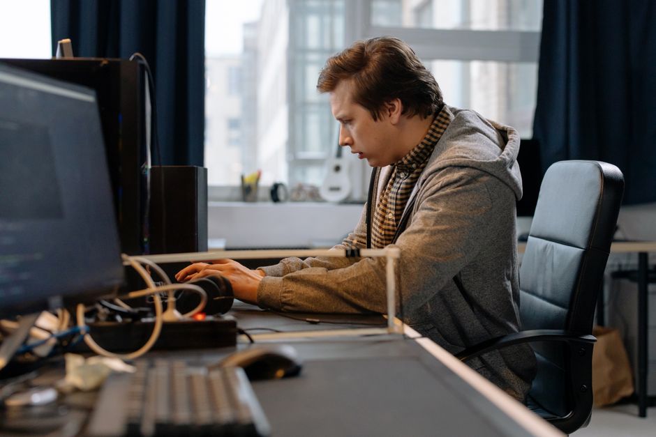 Teilnehmende in einer kleinen Gruppe beim Programmieren in einem Kursraum